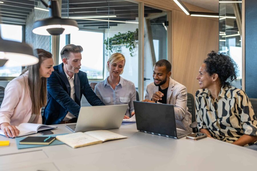 corporate office colleagues working at a meeting table.